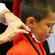 Chorister Nathanael Wain holds still while his robe is adjusted.
