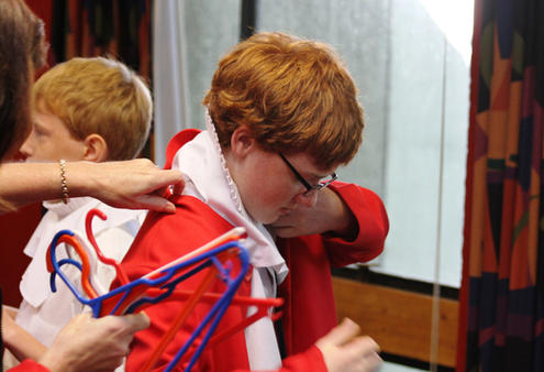 Patrick Manning gets a hand to slip into his chorister's robe.
