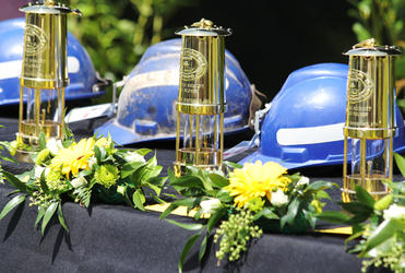 In front of the stage was a black-draped table bearing 29 miners' helmets and lanterns - engraved with the names of the lost miners.