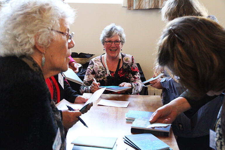 The "Word-Catcher" - the Rev Lynne Frith, Minister at the Pitt St Methodist Church - signs the new book.