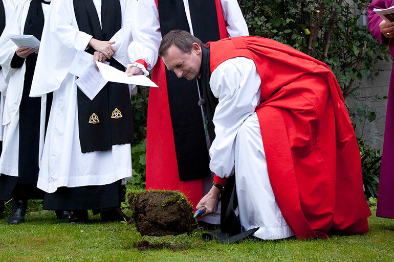 The Bishop of Auckland, Ross Bay, turns the first sod at the ground-breaking ceremony.