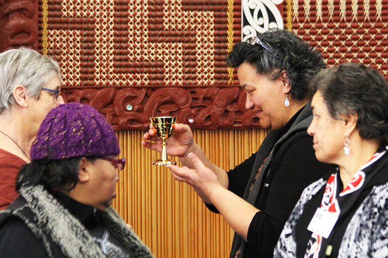 Ema Weepu, of Te Upoko Te Ika, receives the chalice from Erice Fairbrother (partially obscured.) 