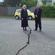 Bishop Victoria and Archbishop David stand either side of the rift in the road outside Churchill Courts' aged care complex.