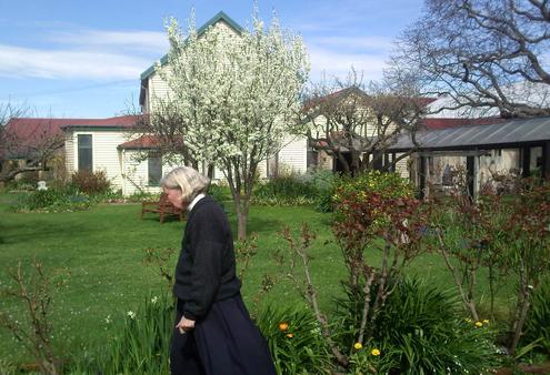 Bishop Victoria walks past the blossoming Victoria Plum tree in the convent's enclosed garden.