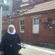 Sister Sandra, CSN, outside the convent's condemned laundry block. Note the damage done by the fallen chimney.