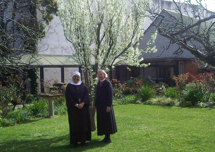 Sr Sandra and Bishop Victoria in the enclosed convent garden. The nuns have moved into modern retreat buildings at right.