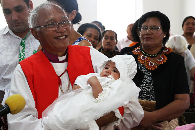 Archbishop Winston Halapua holding Robert Sullivan, the first baby to be baptised in the refurbished church.