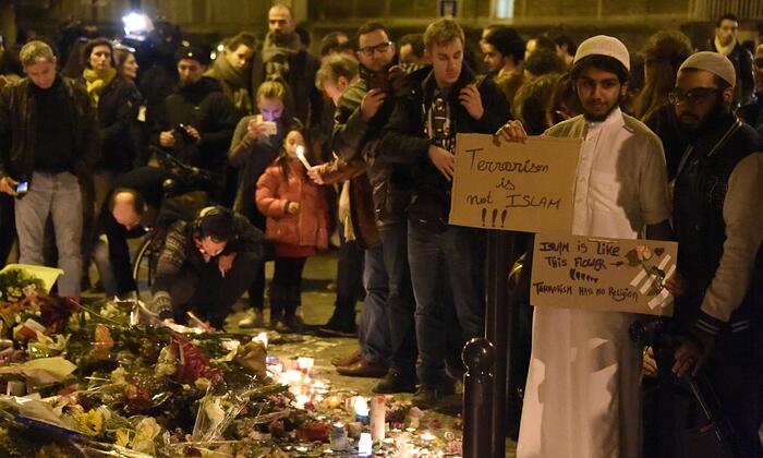 A Muslim holds a placard reading "Terrorism is not Islam" during a gathering outside Le Carillon restaurant in Paris.