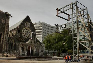 Emergency workers stand near the frame that will be used to hold the facade of ChristChurch Cathedral in place. Photo: The Press