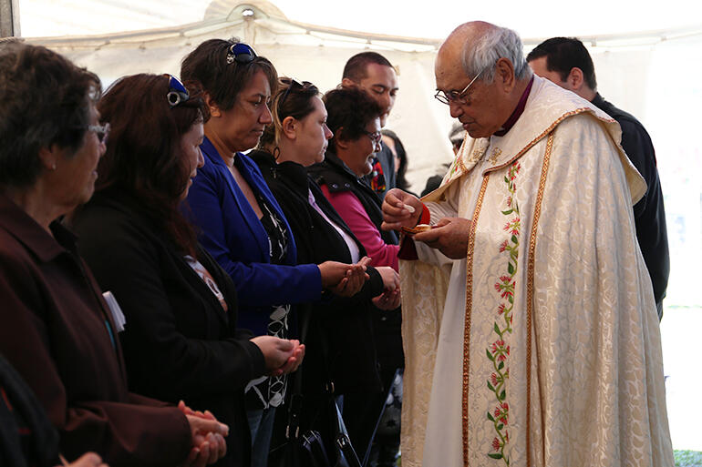 Archbishop Brown distributes the host at the rededication of Hoani Tapu, Rangitukia. They'd erected a marquee to accommodate an overflow crowd.