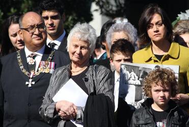 Lady Reeves watches as Sir Paul's casket is loaded into the hearse. Judge Sarah Reeves, their daughter, is wearing the yellow jacket