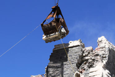 Mechanical teeth nibble a couple of tonnes of cathedral parapet. The tower has been lowered another couple of metres to make it safer.