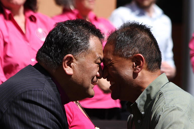 Bishop Kito Pikaahu and John Tapiata greeting each other. Bishop Kito Pikaahu and John Tapiata greeting each other.