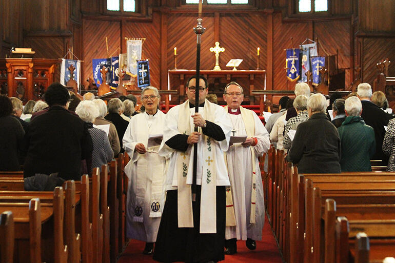 Processing from the church. The Rev Ivica Gregurec is the crucifer, and he's flanked by Rev Iritana Hankins and Archbishop John. Processing from the church. The Rev Ivica Gregurec is the crucifer, and he's flanked by Rev Iritana Hankins and Archbishop John.