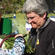 The Rev Marge Tefft, Vicar of Holy Trinity, Greymouth, distributing fern fronds to the mourners at Omoto Racecourse.