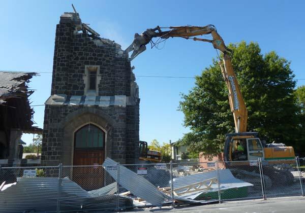 The demolition machine lays waste to the tower of St Mary's, Merivale.