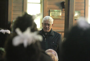 Archdeacon Tiki Raumati, the first speaker for Taranaki, seen through heads adorned with the raukura, the white feathers of peace.