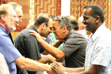 The Rev George Al-Kopti hongis the Rev Brent Swann - while Fr Vallaidam and Dr Tovey seem pleased to greet each other.