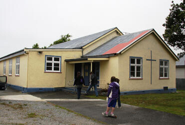 On a solemn Sunday, parishioners arrive at the Church of the Resurrection in Cobden.