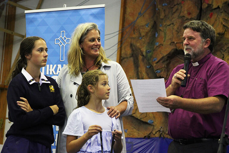 Archbishop Philip Richardson welcomes Jax - while her daughters Libby Jane and Leah look on.