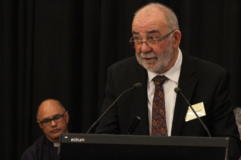 Matua Kim Workman talks while Rev Dr Paul Reynolds (Upoko o te Ika) waits to support the motion. Matua Kim Workman talks while Rev Dr Paul Reynolds (Upoko o te Ika) waits to support the motion.