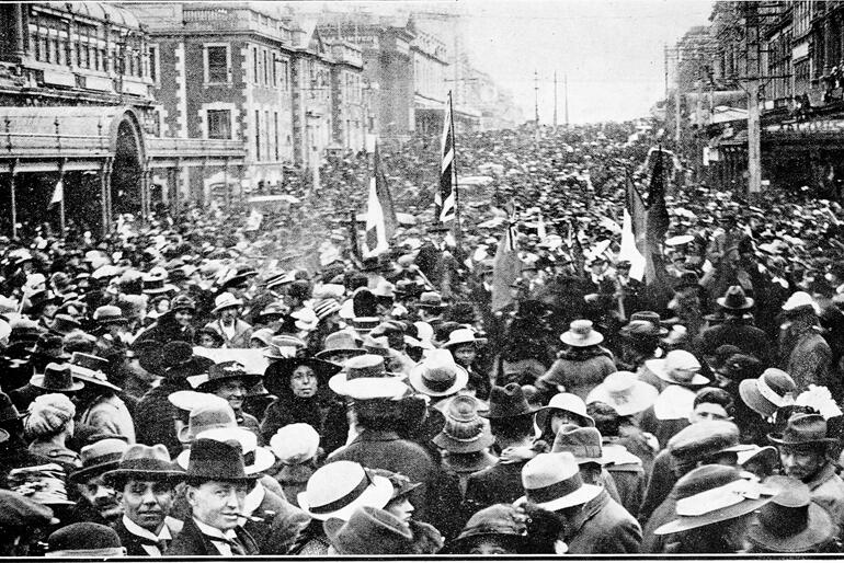 A crowd celebrates Armistice in front of the Stock Exchange, Dunedin 1918. Photo: Sir George Grey Special Collections, Auckland Libraries. 