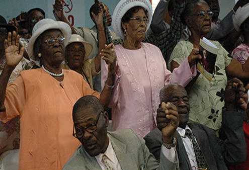 Jamaicans at the ACC's opening Eucharist join hands to sing a call-and-response version of the Lord's Prayer.