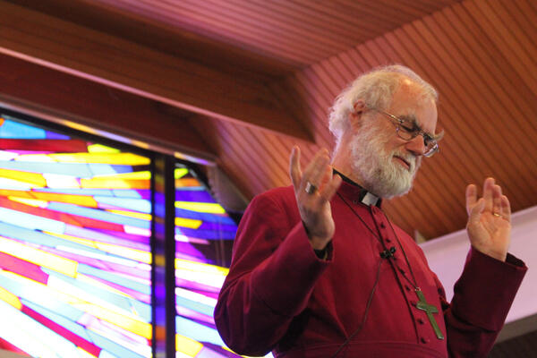 Archbishop Rowan is bathed in the colours of the contemporary stainless glass in St Christopher's, Avonhead.