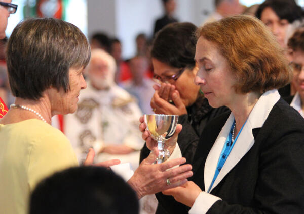 Dr Jane Williams (right), the Archbishop's wife, receives the cup of blessing from Pauline Massey.