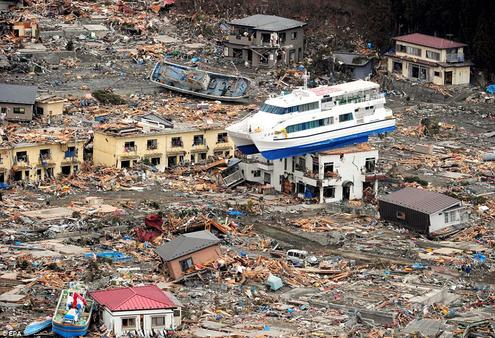 A ship is perched on top of a house in the tsunami-devastated remains of Otsuchi, Iwate prefecture. Photo: EPA