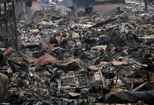Rescue workers are dwarfed by the rubble as they pick their way through the shattered city of Otsuchi. Photo: Reuters