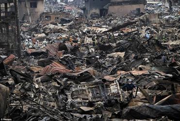 Rescue workers are dwarfed by the rubble as they pick their way through the shattered city of Otsuchi. Photo: Reuters