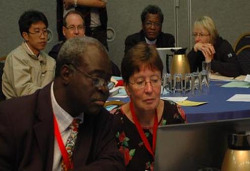 Abraham Yisa (Nigeria) and the Rev Janet Trisk (Southern Africa) follow the debate during an ACC plenary meeting in Kingston.