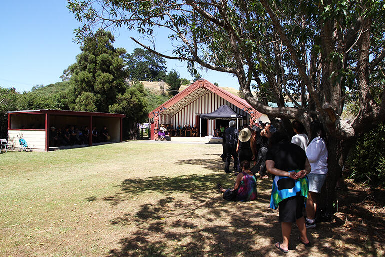 Taking shelter from the sun during the powhiri at Rongomaianiwaniwa, Tikitiki.