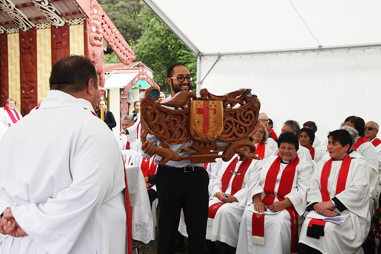 Isaac Beach holding the pare, or lintel, given to the new bishop by Manawa o Te Wheke.