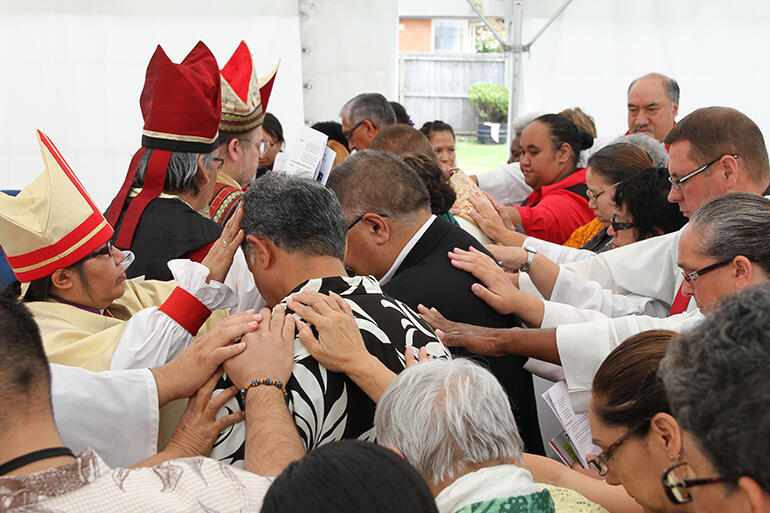 The bishops and the various delegates lay hands on the new AIN Executive Committee members.