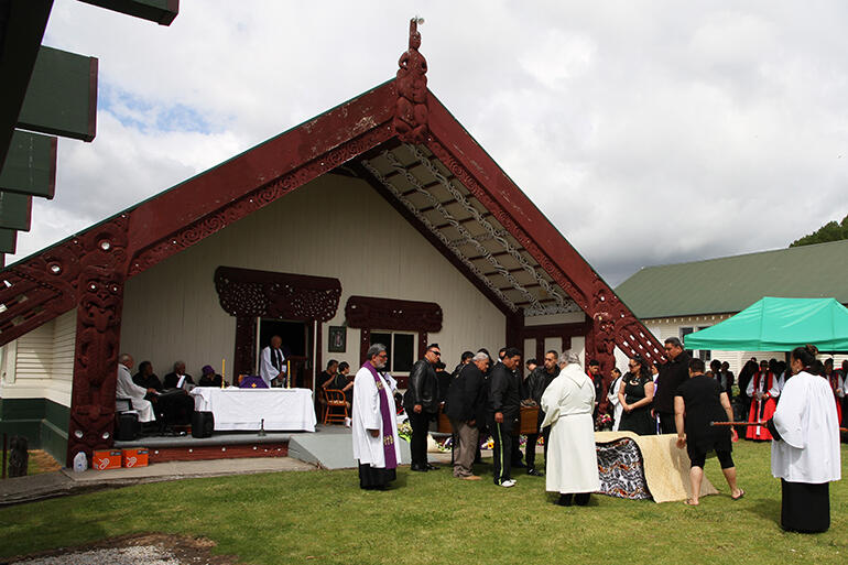 Bishop John is brought from the porch of the wharenui to lie in the marae atea for the funeral service.