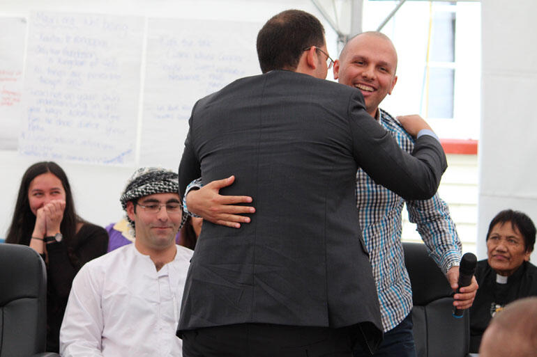 David Cumin, a Jew, and Tamer Elhardy, a Muslim, embrace during the discussion on Israel and Palestine.