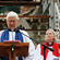 With the shattered west wall of the cathedral as a backdrop, Dean Peter Beck gives his mihi to the mourners.