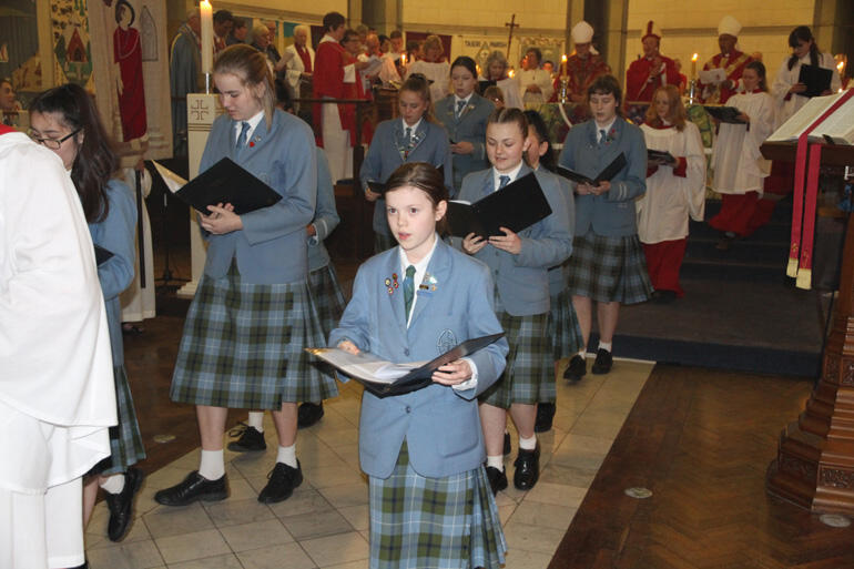 Singers from St Hilda's Collegiate process out before their new bishop.