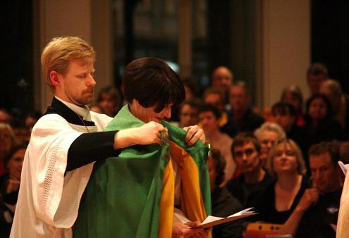 Richard Ericksen, the cathedral's master of ceremonies, places the dean's new cope around Jo's shoulders.