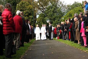 John McAlpine, Jenny's husband and co-vicar, leading the hearse, flanked by Anne Priestley and James Harrison, Jenny's son. 