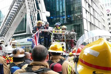Bishop Ross stands by in the basket of Parnell Station’s turntable ladder as a colleague recites the names of the fallen firefighters.