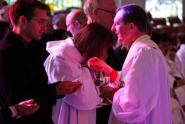 Bathed in the light cast by the Cathedral's stained glass windows, Bishop Ross Bay distributes the communion.