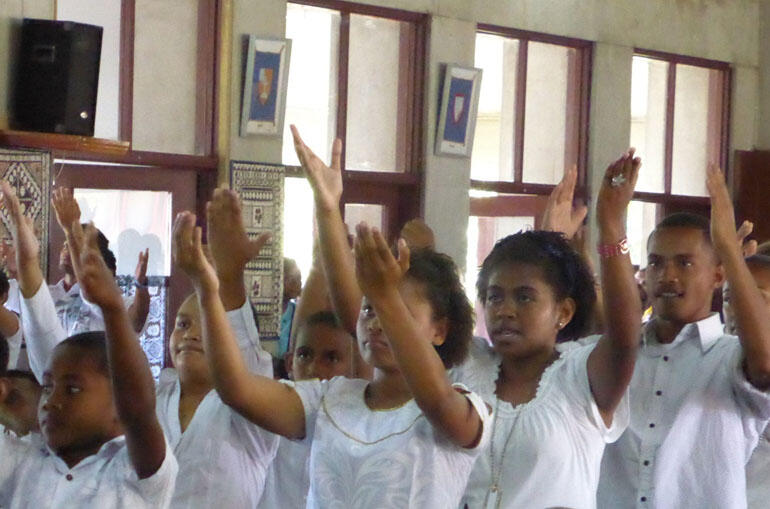 Hands lift to God in praise during the service of thanksgiving in Holy Trinity Cathedral, Suva.