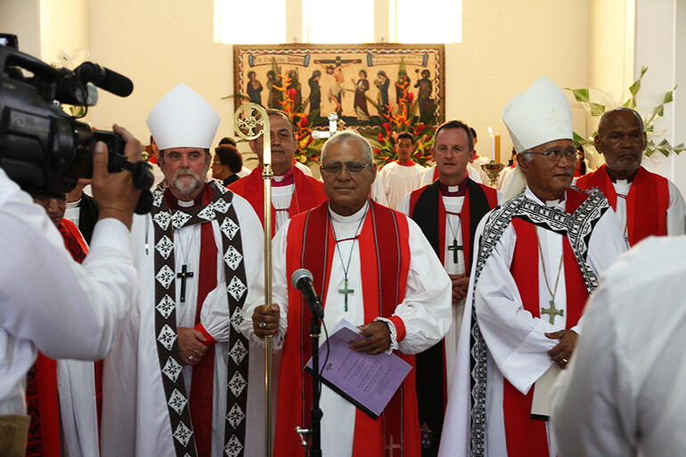With the archbishops on either side, the newly ordained Bishop 'Afa Vaka is presented to the people. With the archbishops on either side, the newly ordained Bishop 'Afa Vaka is presented to the people.