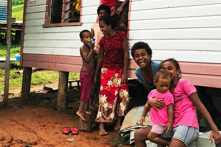 Satisfied customers - a gaggle of Maniava kids outside one of the new cyclone-proof houses.