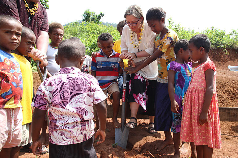 Bishop Helen-Ann Hartley turns the first sod, with some help from her friends.