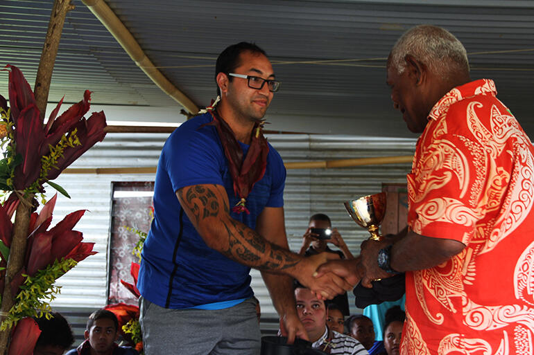 Isaac Beach presents Mosese Kakaramu, the koro headman, with a communion set.