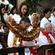 Archbishop David bows his head as he is wreathed in a Pacific garland.